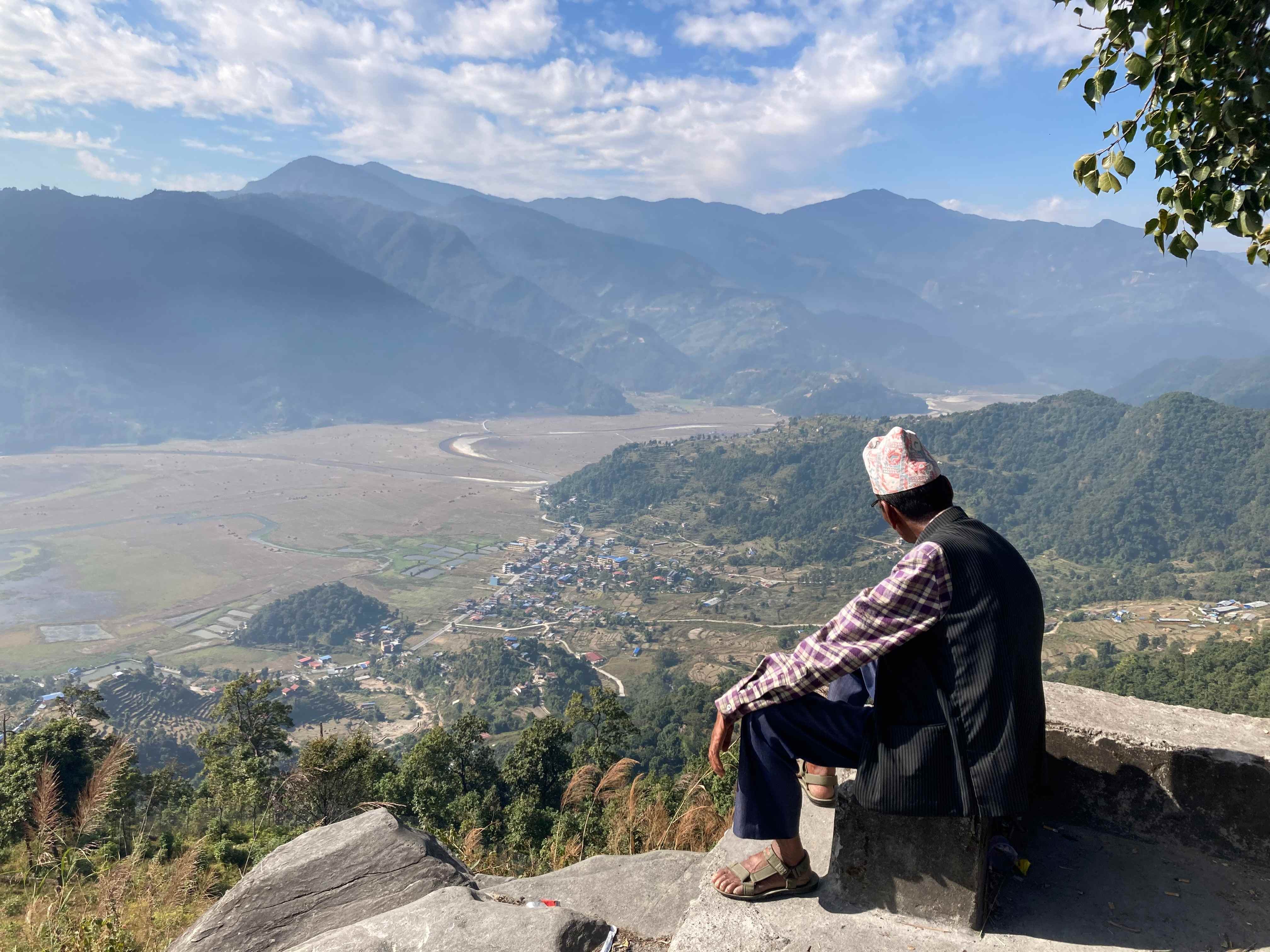 Man with typical Nepali hat looking at Pokhara from above